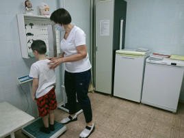 Медсестра измеряет вес ребенка Медсестра измеряет вес ребенка.
